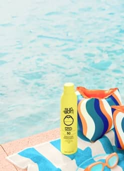 Express Delivery. Floaties, a towel, goggles and sunblock next to pool water.