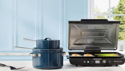 Caraway cookware, Ninja Sizzle Pro and spatula on kitchen countertop.