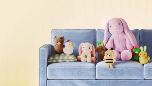 Blue sofa with a selection of bunny and duck plushies in different sizes.