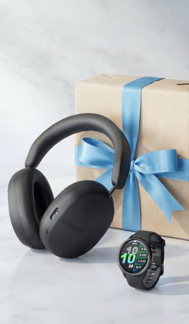 Sonos headphones and Garmin watch in front of wrapped gift box.
