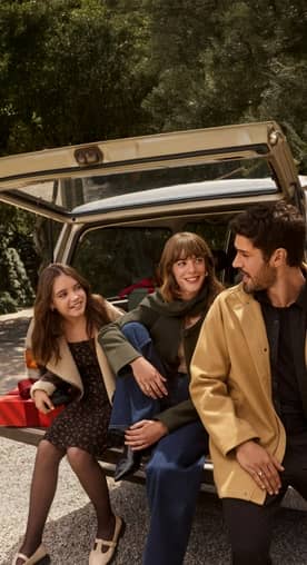 A family of three is shown, each wearing cold-weather styles ranging from a sherpa coat to a wool jacket, sweaters and a scarf.