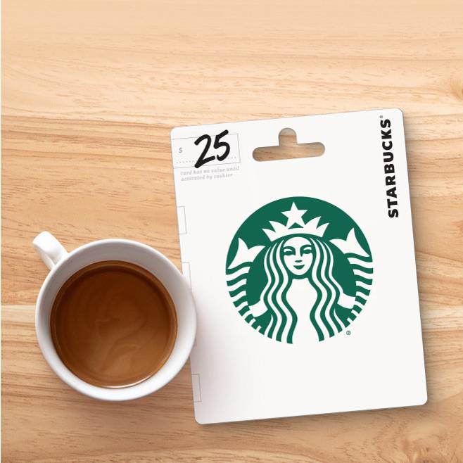 An image of a coffee cup net to a Starbucks gift card on a wood table.