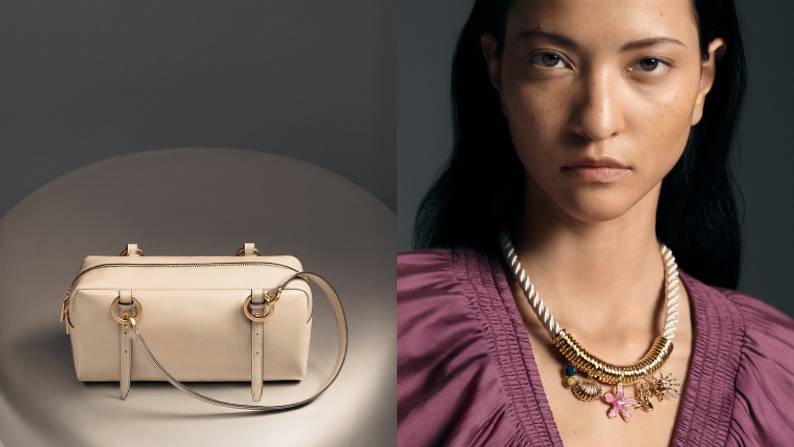 Cream east-west structured handbag with goldtone hardware displayed beside a woman wearing a layered pendant necklace.