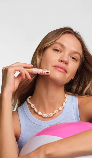 Lifestyle shot of model holding mascara with text: New makeup arrivals, from $6. Shop now.