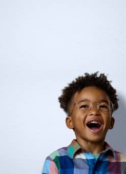 A little boy wearing circular eyeglasses. Advertising frames for kids.