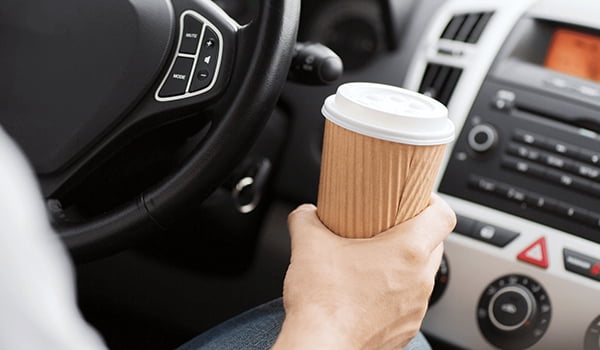 What is distracted driving Distracted driver with coffee and looking at stereo