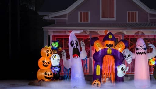 Image of a yard with inflatables: ghosts, a tower of pumpkins and a haunted house. Bring characters to life. Frightfully fun inflatables. Shop now.