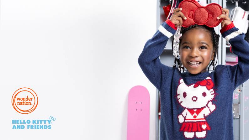 Smiling girl in navy Hello Kitty sweater holds a red bow purse above her head in front of lockers and a pink skateboard.