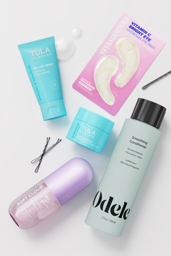 Tula and Odele skincare and haircare products with Vitamin C bright eye patches and hairpins arranged in a flat lay.
