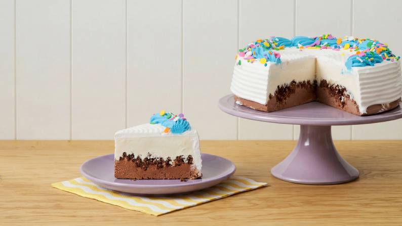 A chocolate ice cream cake on a cake stand.