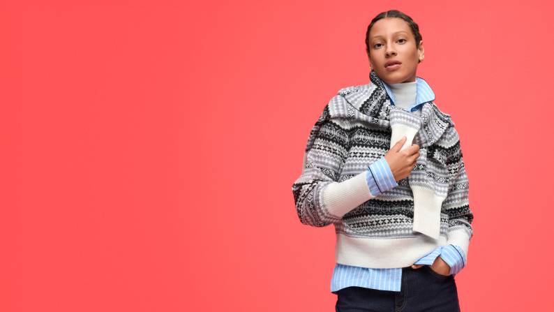 A woman is shown wearing Free Assembly black and white snowflake Fair Isle pullover sweater with tall cuffs.