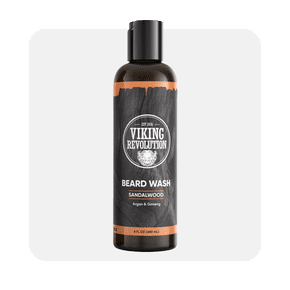 Image shows an eight-ounce bottle of Viking Revolution beard wash in sandalwood scent, featuring argan and ginseng, on a light gray background.