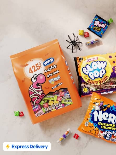 Express Delivery badge. Assorted Halloween candy with large mixed bag plus Blow Pop Creepy Treats and Nerds gummy clusters on a light surface.