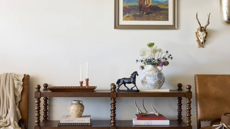 An image of rustic decor in a home including a painting, vases & a small horse statue.