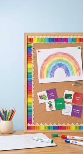 A bulletin board covered in paper patterned with colorful pencils.