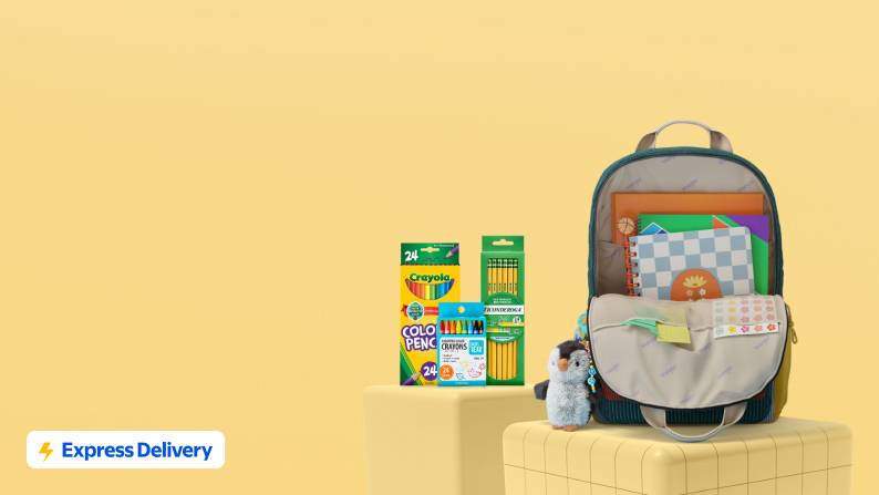 Express Delivery. A backpack filled with and surrounded by school supplies and a plush penguin charm