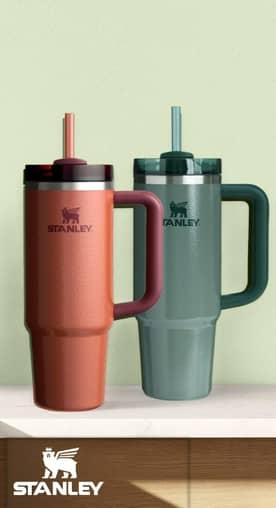An image of multicolored Stanley tumblers on a green background.