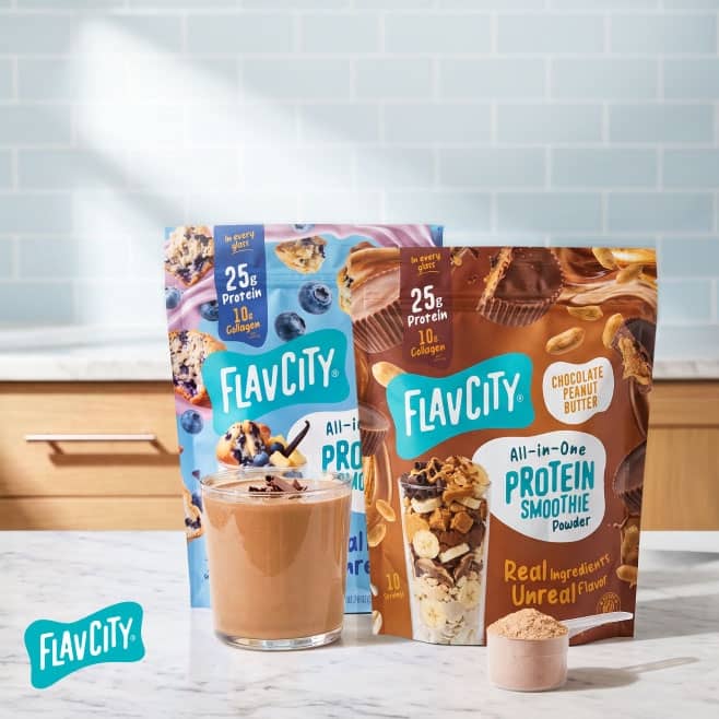 Flavcity All in One Protein Smoothie powder bags in berry and chocolate peanut butter flavors with a prepared smoothie and scoop of powder.