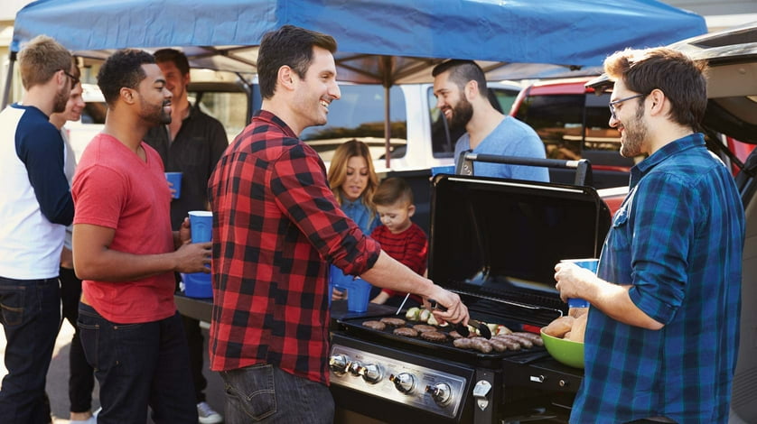A group of men enjoy an outdoor barbecue together.