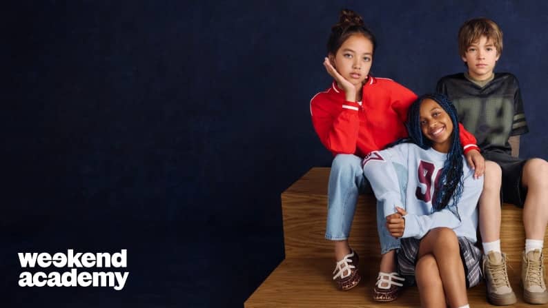 Three tweens in fall back to school outfits including a varsity style jacket, graphic sweatshirt, plaid skirt, denim and shorts.
