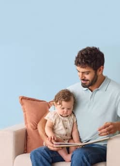 Father with a baby on his lap reading a book.