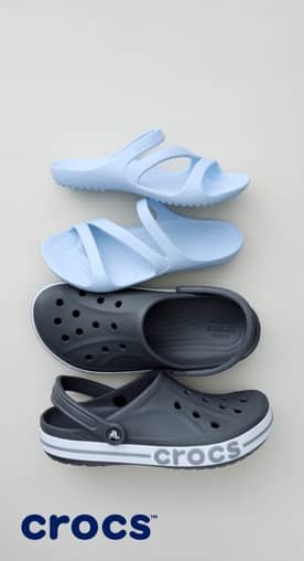 A pair of light blue crocs sandals and a pair of black crocs on a gray background.