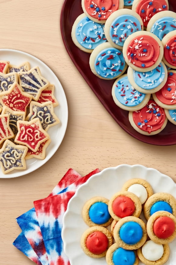 Three plates with assorted red, white and blue frosted cookies.