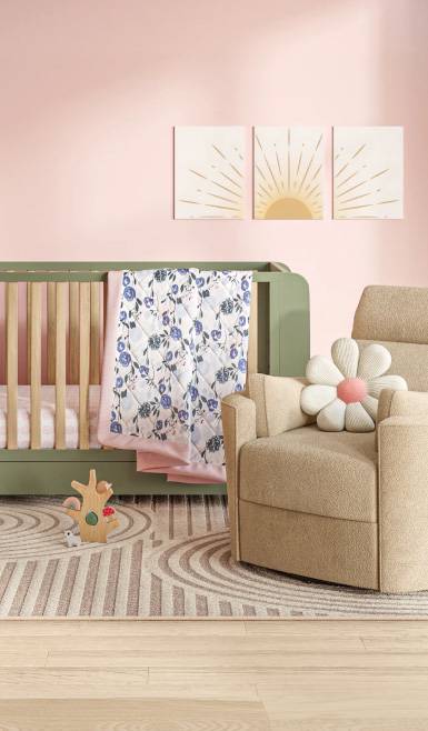 A nursery decorated with a two-tone crib, reclining plush chair with flower throw pillow, geo-embellished rub and a paneled sunrise wall picture.