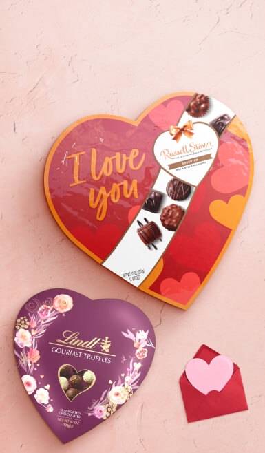 A Russell Stover heart-shaped chocolates box is shown next to a Lindt gourmet truffle heart-shaped box.