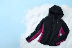 A women’s black and pink heated jacket with detachable hood is shown against a snowy background.