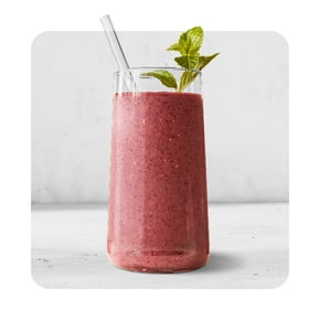 A smoothie in a tall glass with a fresh garnish is shown.