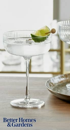 An aerial shot of wooden kitchen tools and a beige linen napkin is seen against a slate countertop.