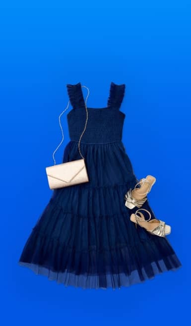 Image shows a navy-blue dress with a tulle overlay, a pair of gold strappy sandals, and a chrome shoulder bag.