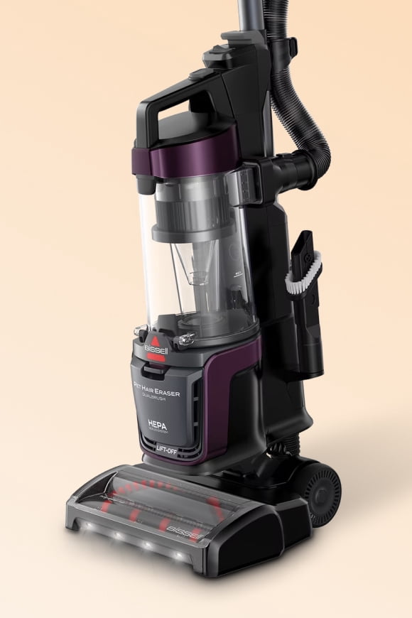 Bissell upright vacuum cleaner with clear dust canister, hose attachment and front LED lights.