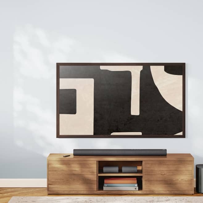 An onn art TV displaying a black and white abstract artwork on a wooden console table.