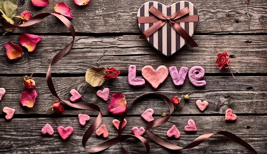 wooden table with cut out hears and flower petals and the word love
