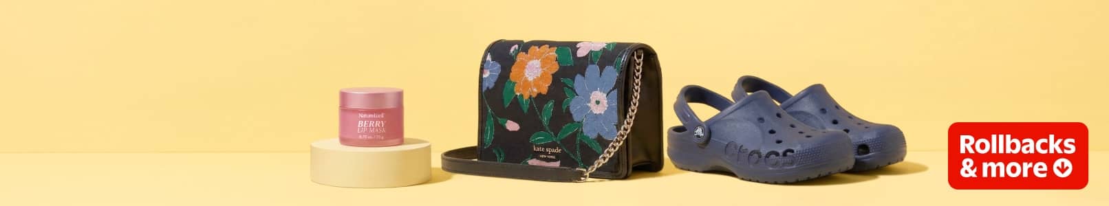 Rollbacks and more. A pink jar of Nature Well berry lip maska black and floral print Kate Spade handbag and a pair of dark blue Crocs.