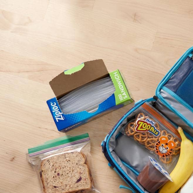 A packed lunch box, Ziploc bags and a sandwich stored in a plastic baggie is shown.