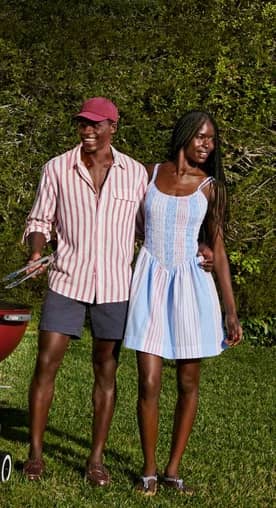 A man and woman wearing red, white and blue outfits are outside walking together.