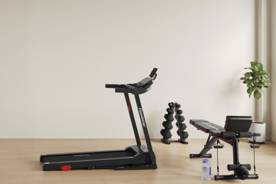 An image of a treadmill, a weight bench and weights on a light wood floor in a beige room. Text says: From $9.97.