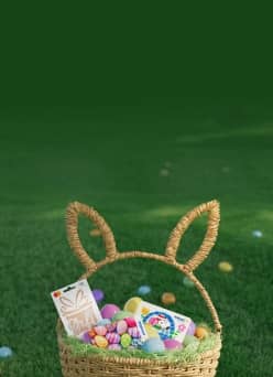Easter basket with bunny ears filled with colorful eggs, a gift card, and more gifts.