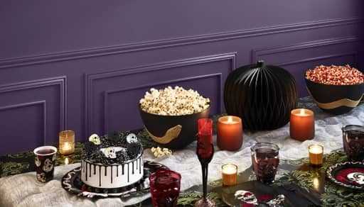 Black and red table setting with plates, cutlery and dishes filled with food.
