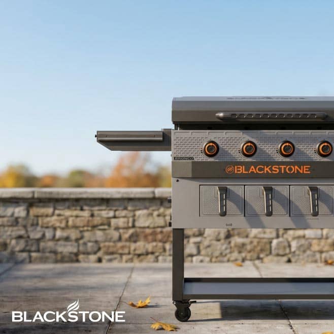 A grill in front of a stone wall.