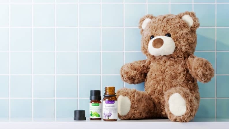 View two bottles of essential oils and a fuzzy brown teddy bear. Up to fourty percent off.