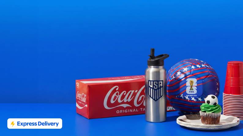 Express Delivery. Twelve pack of Coke, Team USA water bottle, red, white and blue soccer ball, cupcake on a stack of paper plates and plastic cups.