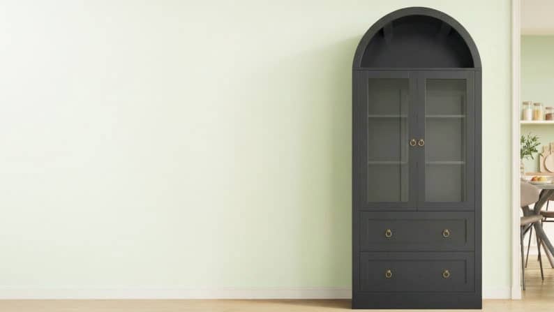 View a tall, dark wood cabinet with an arched top and a glass-pained front. Up to thirty-five percent off.