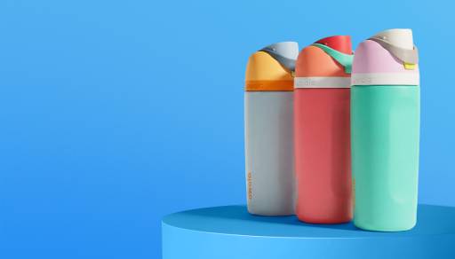 Three colorful reusable water bottles standing upright on a round platform against a blue background.