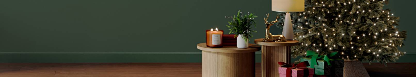 A sage green living room features a coffee table, Christmas tree and festive decor.