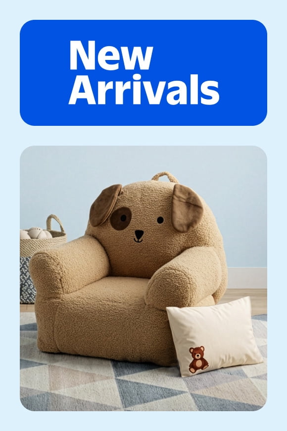 A plush, dog-shaped toddler armchair on a blue geometric rug.