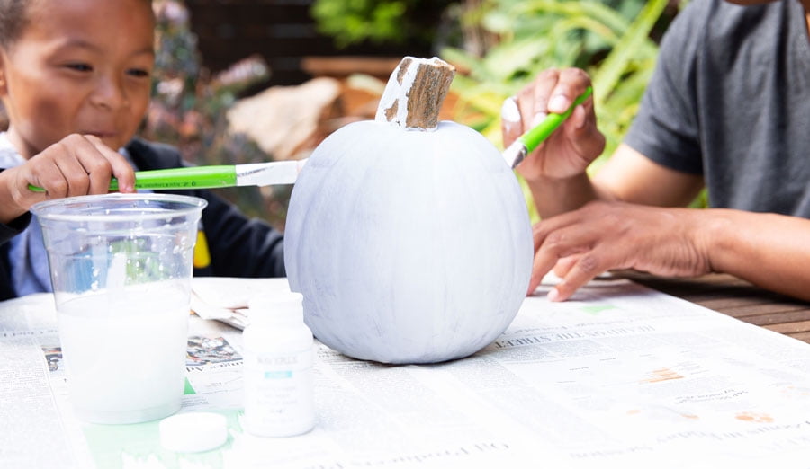 Painting a basecoat on a pumpkin